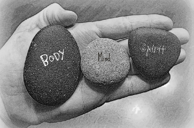 Image of three pebbles with the words body mind and spirit on each pebble